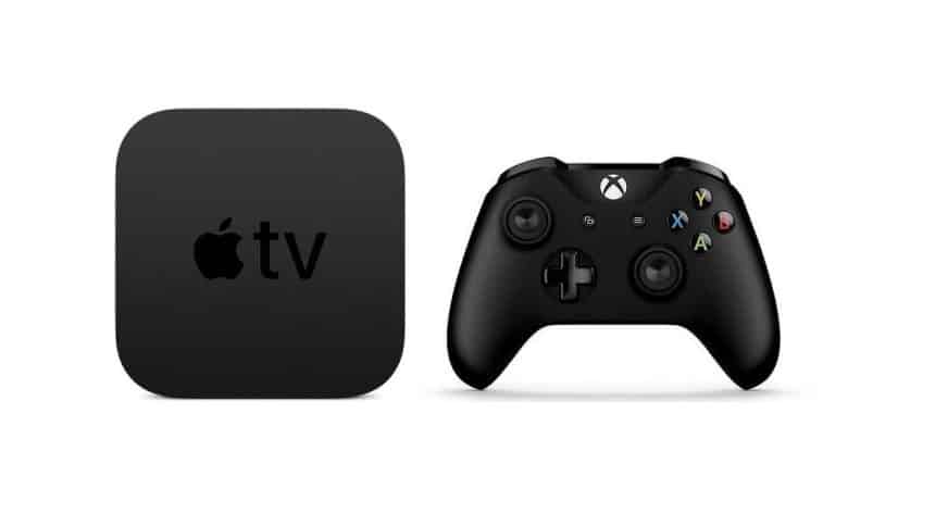 Apple TV device beside a black gaming controller.