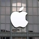 White Apple logo displayed on a glass building facade.
