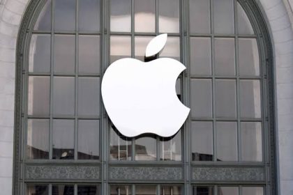 White Apple logo displayed on a glass building facade.