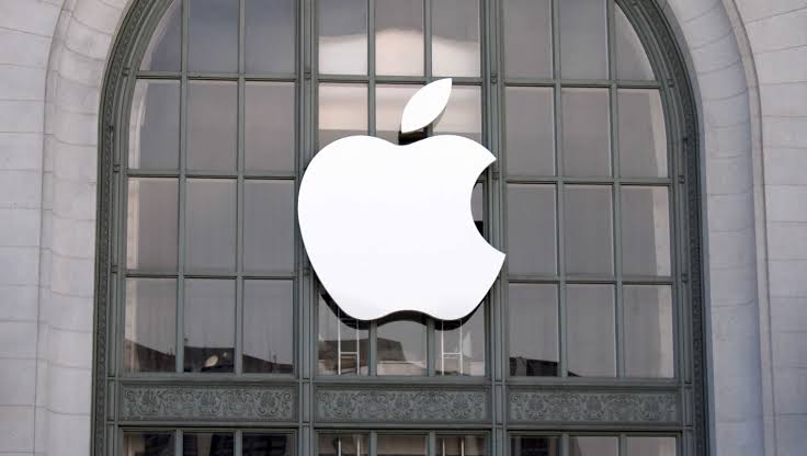 White Apple logo displayed on a glass building facade.