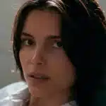 Close-up of a dark-haired woman looking toward the camera.