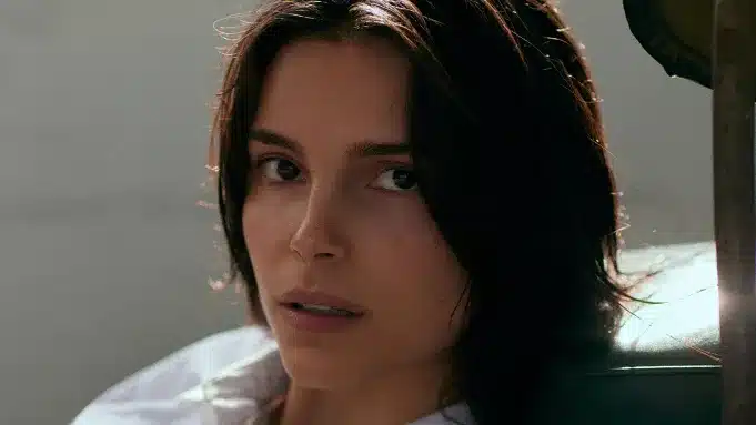 Close-up of a dark-haired woman looking toward the camera.