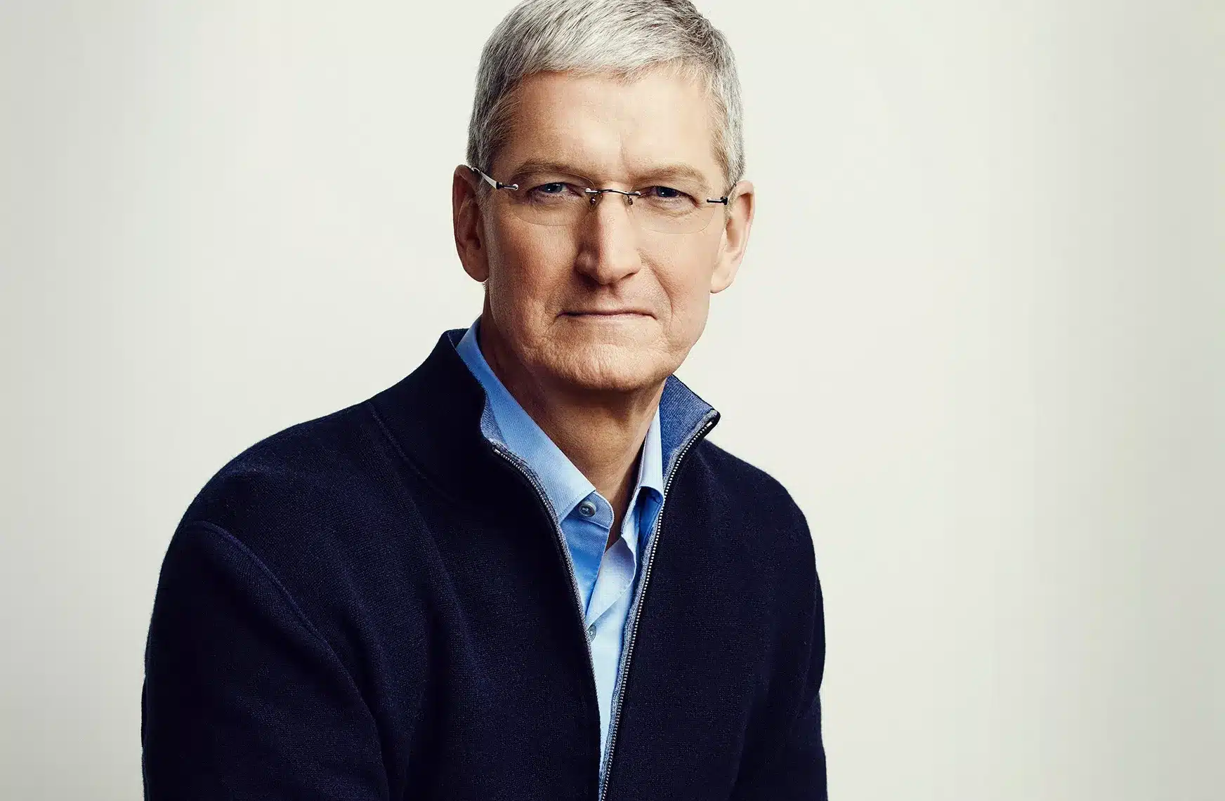 Portrait of a gray-haired man wearing glasses and a dark sweater.
