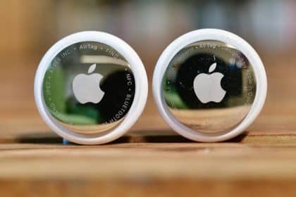 Two Apple AirTags displayed side by side on a wooden surface.