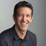 Smiling man in a dark polo shirt.