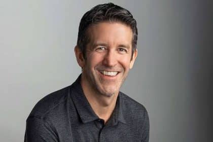 Smiling man in a dark polo shirt.