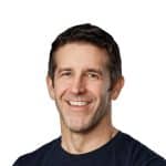 Apple CEO John Ternus smiling in a portrait against a white background.