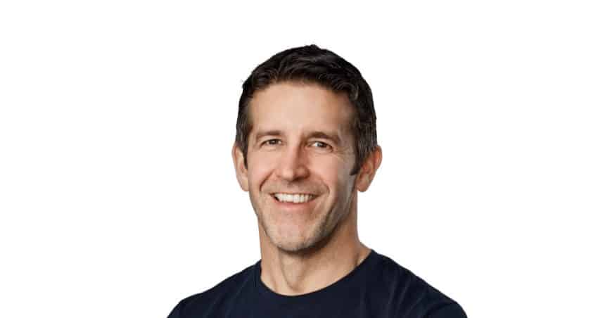 Apple CEO John Ternus smiling in a portrait against a white background.