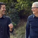 Two smiling men walking together outdoors.