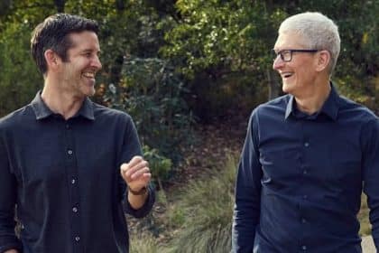 Two smiling men walking together outdoors.