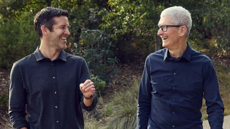 Two smiling men walking together outdoors.