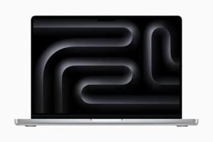 Silver MacBook Pro with a dark abstract wallpaper displayed on its screen.
