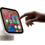 Hand interacting with an Apple HomeView smart display showing apps and widgets.