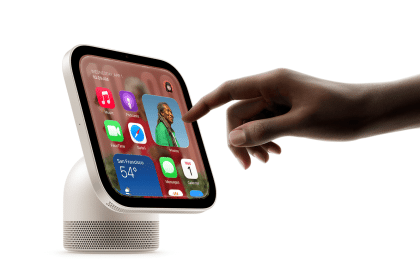 Hand interacting with an Apple HomeView smart display showing apps and widgets.