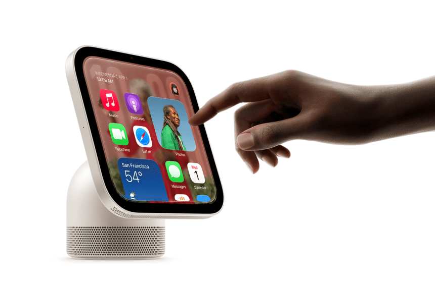 Hand interacting with an Apple HomeView smart display showing apps and widgets.