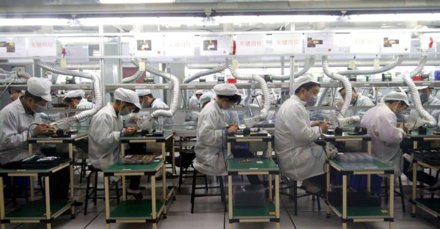 Workers assembling electronic components on a Foxconn factory production line.