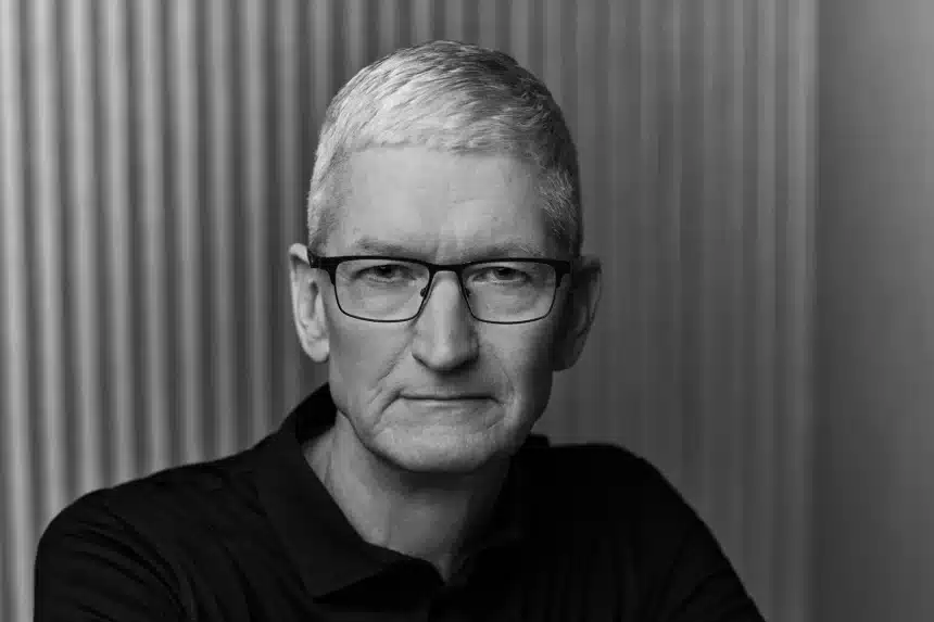 Black-and-white portrait of a gray-haired man wearing glasses and a dark polo shirt.