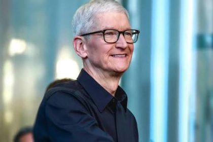 Smiling gray-haired man wearing glasses and a dark shirt.