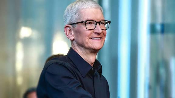 Smiling gray-haired man wearing glasses and a dark shirt.
