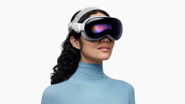 Woman wearing an Apple Vision Pro headset against a white background.
